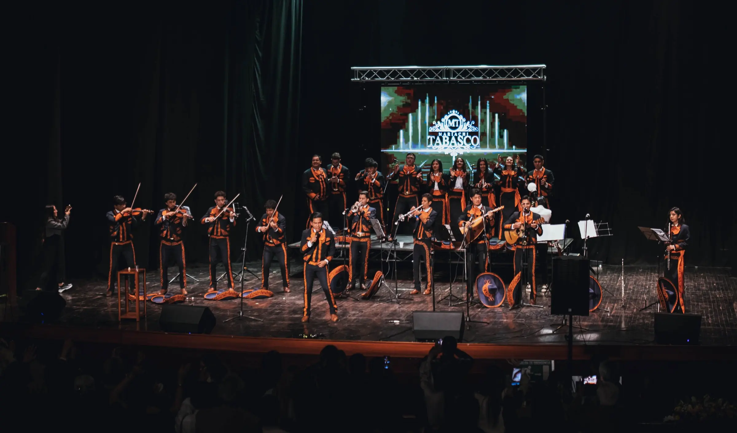 Mariachi Tabasco en concierto con su logo en la pantalla del escenario
